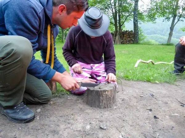 Messer schneidet Holz auf einem Baumstumpf während einer Holzarbeitssitzung