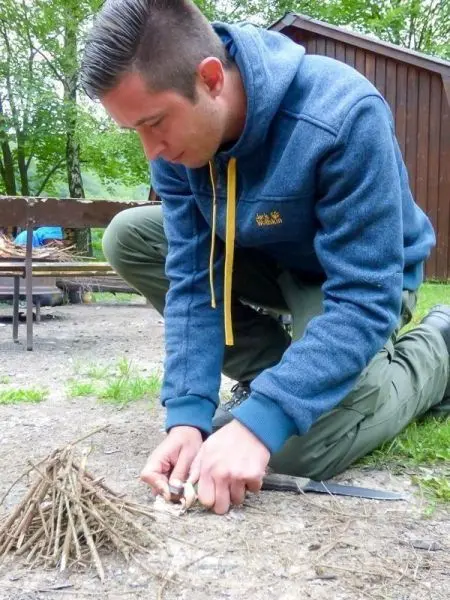 Zunder wird mit einem Messer aus kleinen Ästen vorbereitet