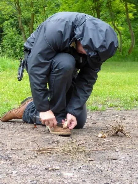 Zunder wird neben einer kleinen Holzansammlung vorbereitet