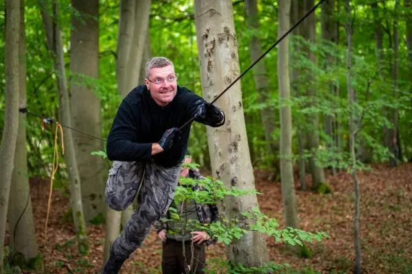 Mann nutzt selbstgebaute Seilbrücke zur Fortbewegung zwischen Bäumen