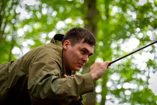 Person zieht an einem Seil im Wald