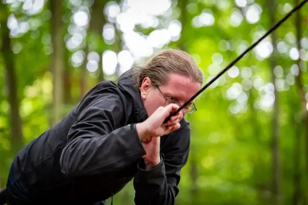 Person zieht an einem Seil im Wald