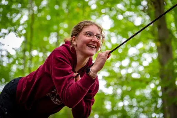 Seil wird gespannt, während eine Person sich an einem Baum festhält