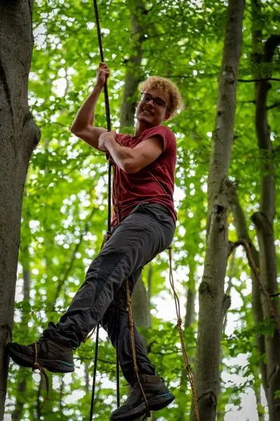 Seilquerung an einem Baumstamm mit Kletterseil und Sicherung