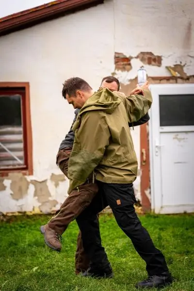 Zwei Personen führen eine Technik zur Unterstützung einer verletzten Person durch