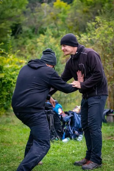 Zwei Personen üben eine Selbstverteidigungstechnik im Freien