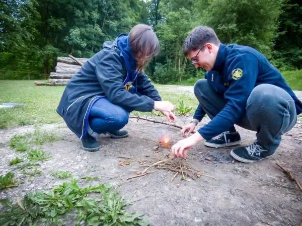 Feuerstahl erzeugt Funken auf Zunder in einem kleinen Holzstapel