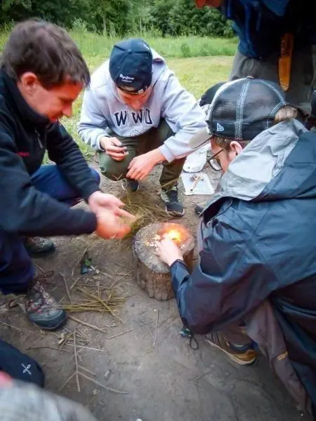 Feuerstahl erzeugt Funken auf Zunder in einer Holzmulde