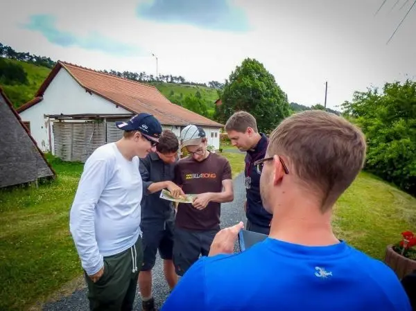 Gruppe betrachtet eine Karte auf einem Weg neben einem Wohngebäude