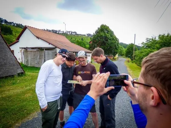 Gruppe betrachtet eine Karte auf einer Straße neben einem Gebäude