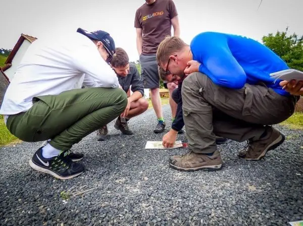 Mehrere Personen betrachten gemeinsam eine Karte auf einem Kiesweg