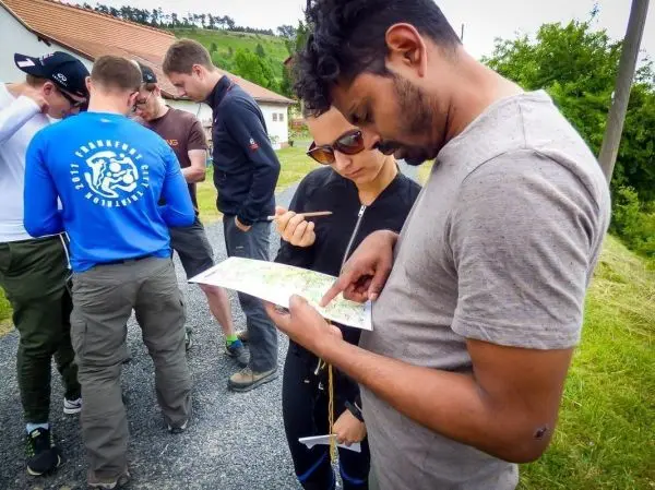 Zwei Personen studieren eine Karte, während andere im Hintergrund stehen