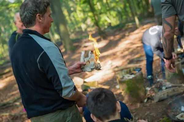 Brennbaumrinde wird als Zunder für ein Feuer verwendet