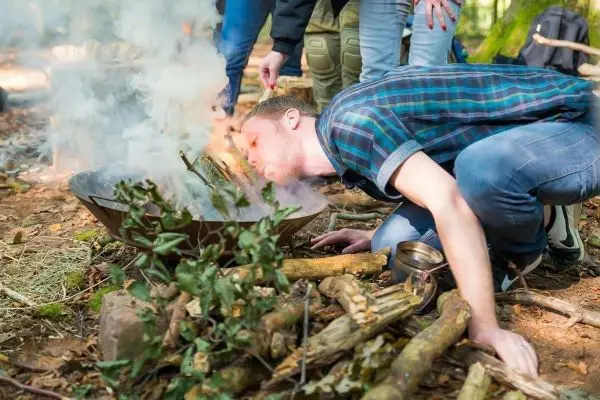 Feuerstahl erzeugt Funken in einer Feuerschale mit Holz