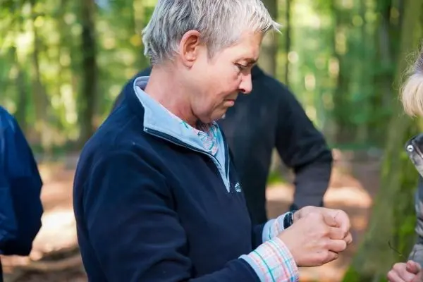Frau bindet eine Schnur in einem Waldgebiet