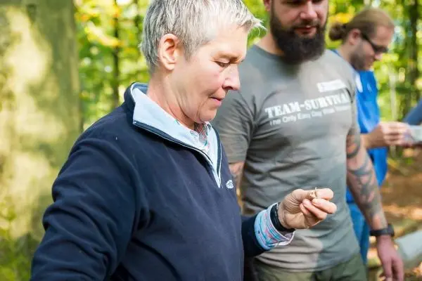 Frau hält ein kleines Objekt in der Hand und betrachtet es aufmerksam