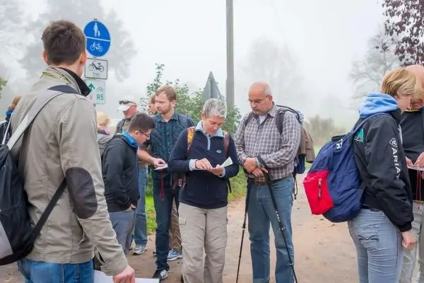 Gruppe betrachtet Kartenmaterial an einem Weg mit Fahrradsymbolen