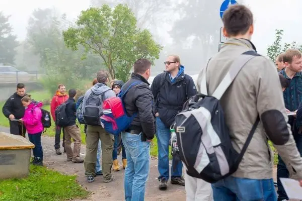 Gruppe von Personen steht an einem Weg und unterhält sich