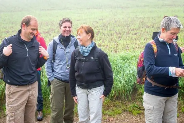 Gruppe von Wanderern in Outdoor-Bekleidung steht auf einem Feldweg
