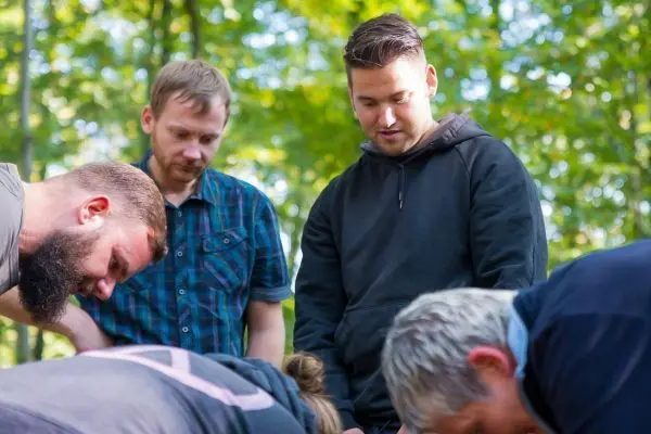 Gruppierung von Personen, die auf den Boden schauen und sich konzentrieren