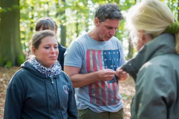 Mann hält ein kleines Objekt in der Hand und spricht mit einer Frau