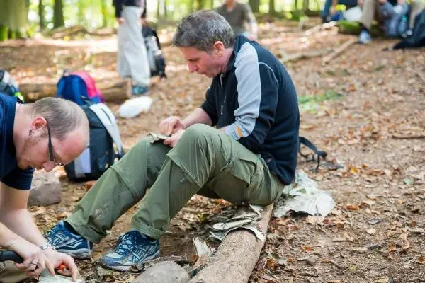 Messer bearbeitet Holzstück auf einem Baumstamm im Wald