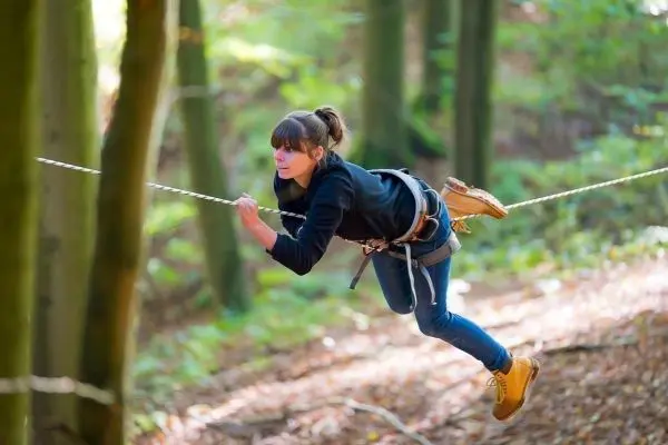 Seilbrücke wird von einer Person im Wald überquert