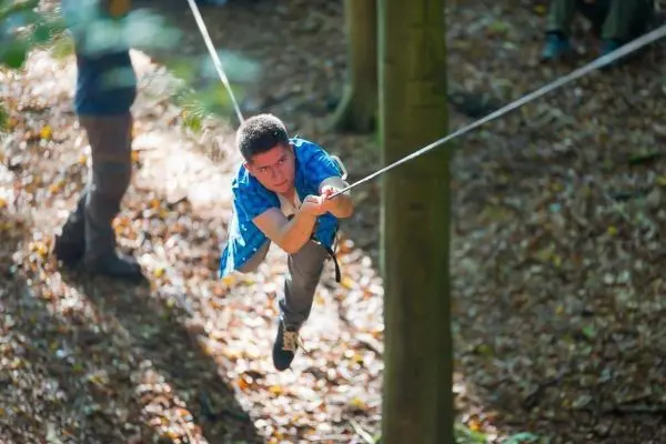 Seilbrücke wird zwischen Bäumen genutzt, um sich fortzubewegen