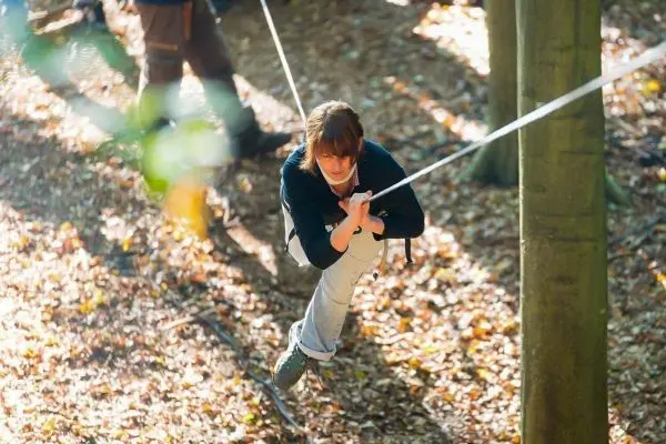 Seilbrücke wird zwischen Bäumen genutzt, um sich fortzubewegen