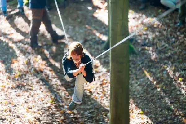 Seilbrücke wird zwischen zwei Bäumen genutzt, um hindurch zu schwingen