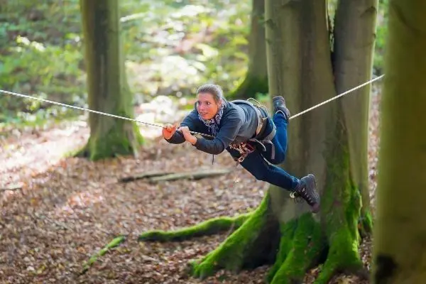 Seilbrücke wird zwischen zwei Bäumen genutzt, um sich schwebend fortzubewegen