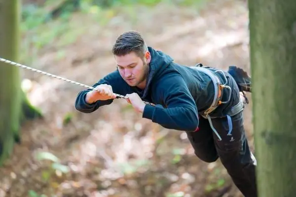 Seilquerung zwischen zwei Bäumen mit Sicherungsgurt und Seil