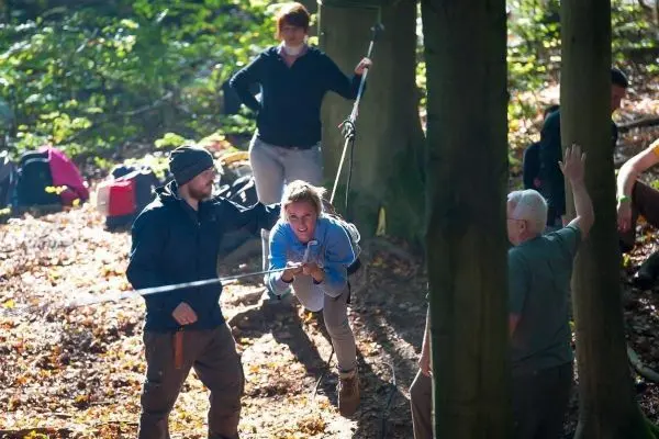 Teilnehmer nutzt eine Seilbrücke zur Überquerung eines Hindernisses im Wald