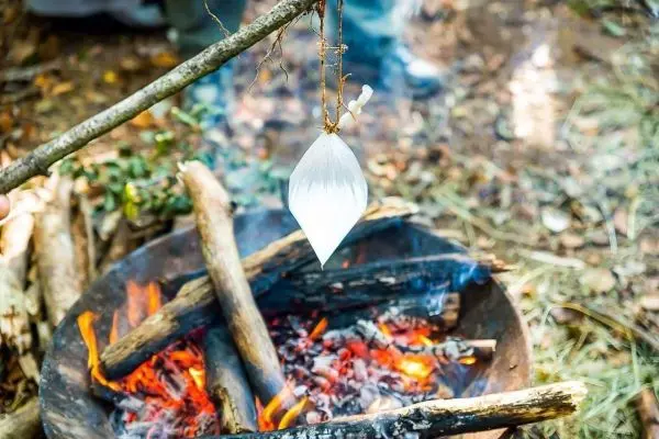 Wasserbeutel hängt über einem Feuer in einer improvisierten Kochstelle