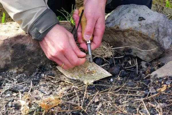 Feuerstahl erzeugt Funken auf Zunder zwischen Steinen