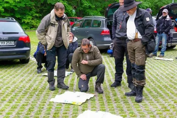 Gruppendiskussion über Kartenmaterial auf dem Boden im Freien