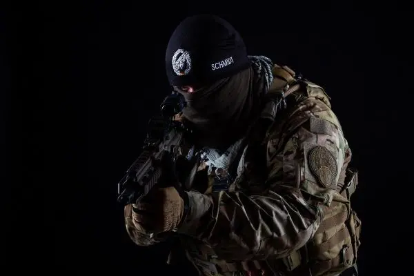 Soldat in Tarnkleidung hält ein Gewehr im Anschlag