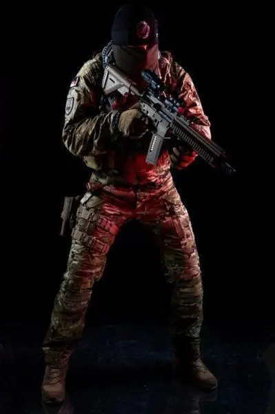 Soldat in Tarnuniform hält ein Gewehr in der Schussposition