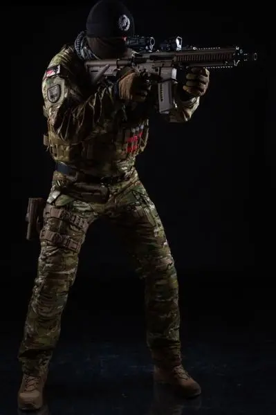 Soldat in Tarnuniform zielt mit einem Gewehr auf ein Ziel