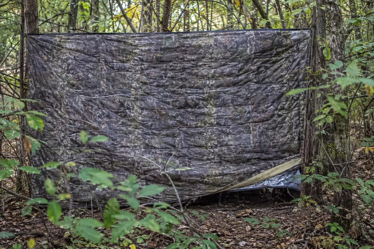 Mehrlagiger isolierter Tarnschirm in einem Waldversteck