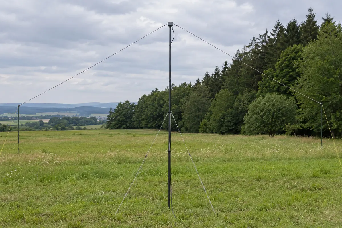 Portabler mittengespeister Inverted-V-Dipol mit Koaxleitung am zentralen Mast auf einer mitteleuropäischen Wiese