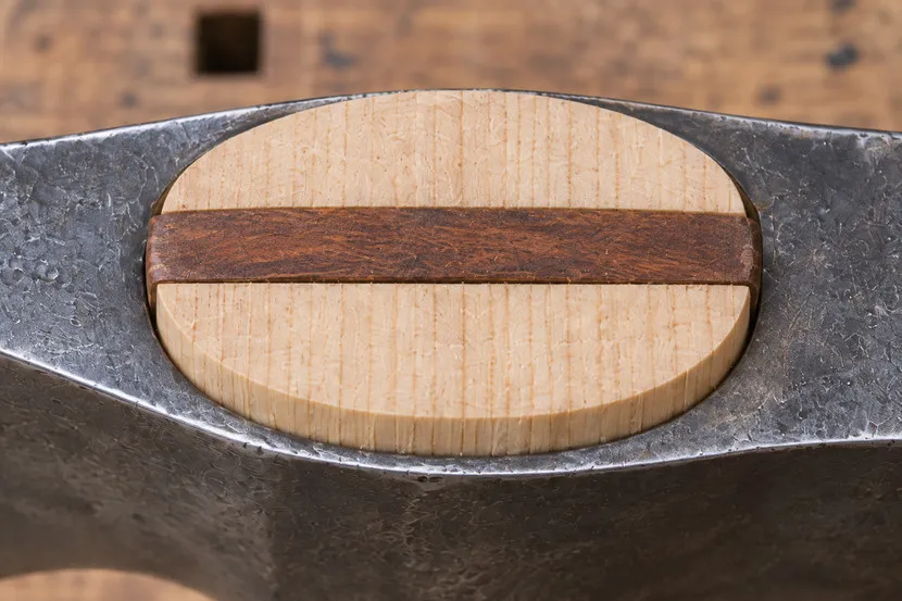 Der Holzkeil liegt längs zwischen Schneidenseite und Nacken.