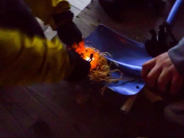 Feuerstahl erzeugt Funken auf Zunder in einer Schaufel