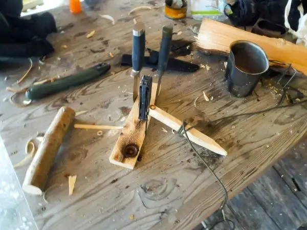 Holzkonstruktion mit Schnüren und Messern auf einem Tisch